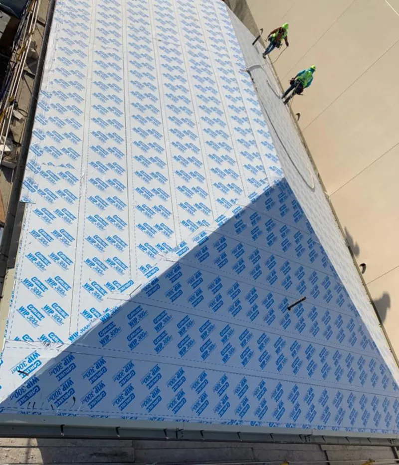 Professional roofers installing underlayment on a metal roof in Upper Merion